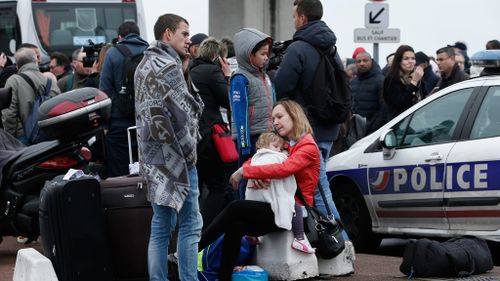 Evacuated travelers wait outside the Orly airport. (AAP)