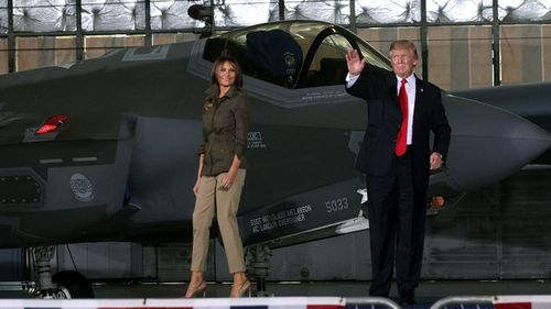 US President Donald Trump waves as first lady Melania Trump looks on after he spoke to Air Force personnel (AFP)