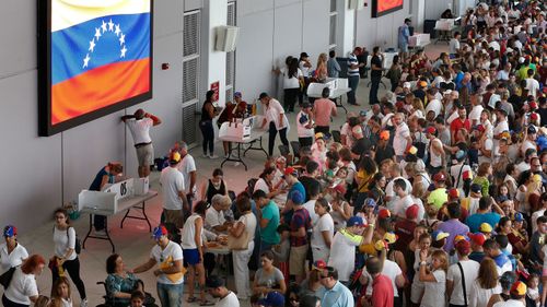 Venezuelan citizens line up to vote in a non-binding referendum against the Venezuelan governement's plans to re-write their constitution to stay in power in Miami, Florida. (Photo: AFP)
