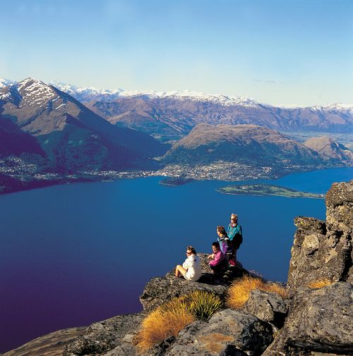 Hikers enjoy the view from Cecil Peak towards Queenstown, New Zealand