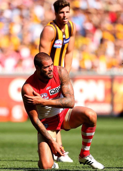 Lance Franklin of the Swans grabs his shoulder after a marking contest with Brian Lake of the Hawks. (Getty)