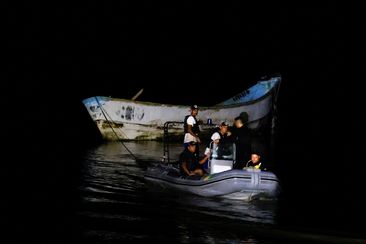 Police officers and rescue workers tow a boat with decomposed bodies found by fishermen, near the Vila do Castelo port in Braganca, Para state, Brazil, on April 14.