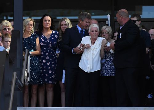 Dean Mercer's wife Reen (2nd left) and his mother Maureen (on right, supported) watch as his coffin is carried away. (AAP)