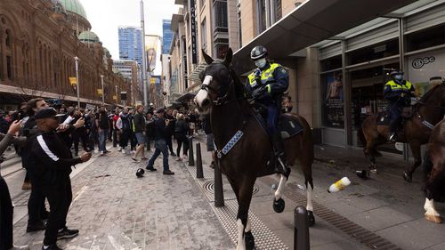 Mounted police are pelted with bottles during an anti-lockdown protest in Sydney's CBD last week.