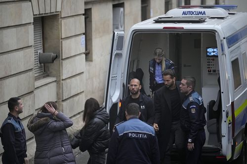 Andrew Tate and his brother Tristan, second right, are brought by police officers to the Court of Appeal, in Bucharest, Romania