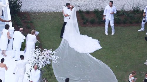 Jennifer Lopez wears a stunning white wedding dress as she celebrates her marriage to Ben Affleck, suitably dashing in a white jacket and black pants. The couple kissed and posed for pics around Bens $8million Georgia mansion on Saturday evening before spending the night celebrating their love and their union with family and a raft of A-list friends.