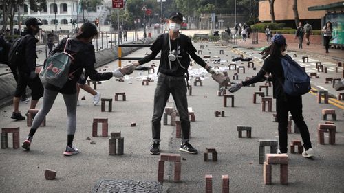 Protestors move bricks as they barricade a road near the Hong Kong Polytechnic University in Hong Kong.