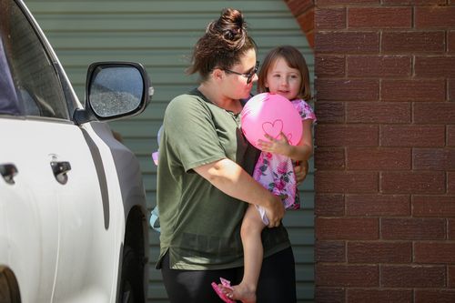 Cleo Smith being carried inside a friends house by her mother  in Carnarvon.
