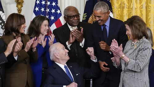 Președintele Joe Biden se uită la fostul președinte Barack Obama după ce a semnat un ordin executiv 