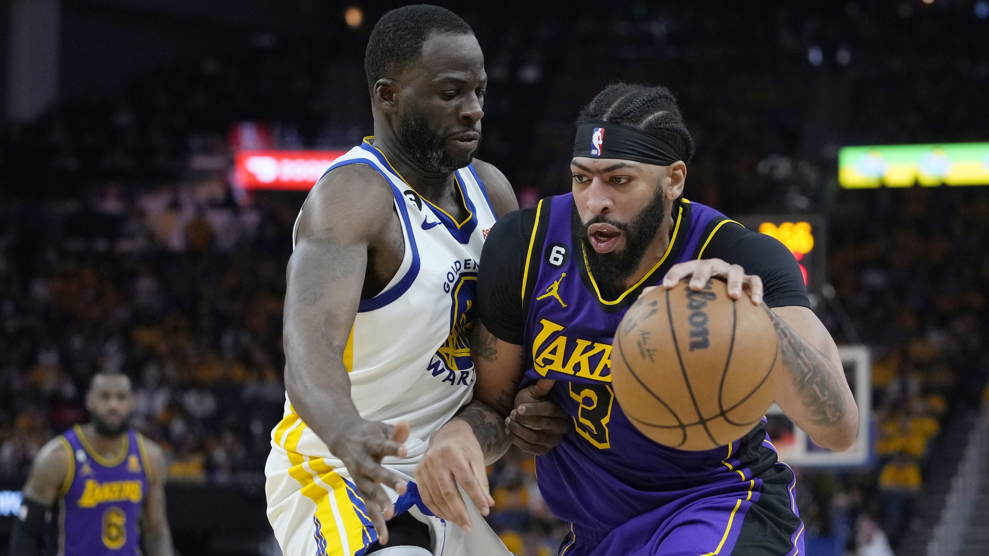 Lakers star Anthony Davis is defended by Draymond Green of the Warriors.