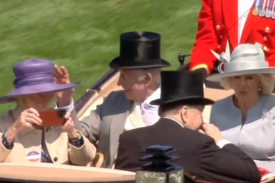 Marchioness of Salisbury records on her phone as she arrives at Royal Ascot 2025 in a carriage with King Charles and Queen Camilla