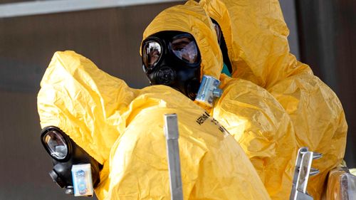 People in protective gear wait to enter a Boeing aircraft of the Italian Air Force with eight of the Italians who were stranded in Wuhan under quarantine measures to contain the coronavirus, at Mario De Bernardi military airport in Pratica di Mare, south of Rome, Italy