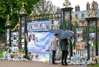 William and Harry view tributes to Diana, Princess of Wales left at the gates of Kensington Palace after visiting the Sunken Garden on August 30, 2017.