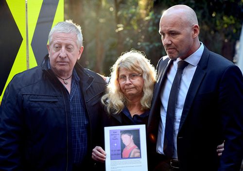 Mark and Faye Leveson, parents of Matthew Leveson, with NSW Police Detective Chief Inspector Gary Jubelin (right) as they hold a picture of Matthew as police continue to exhume human remains found in bushland in the Royal National Park south of Sydney. (AAP)
