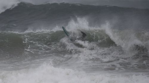 This surfer took on the huge swells at Manly Beach. (AAP)