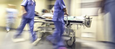Doctors and nurses pulling hospital trolley, emergency room