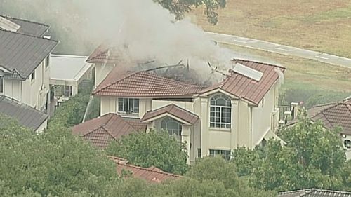 The flames ripped a huge hole in the roof of the house, after it was reportedly struck by lightning. (9NEWS)