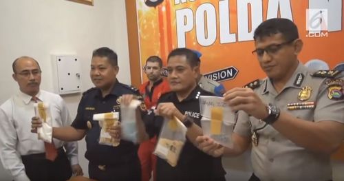 Felix Dorfin (third from left, in orange) was arrested in September for allegedly carrying a false-bottomed suitcase filled with four kilograms of drugs at the airport on Lombok.