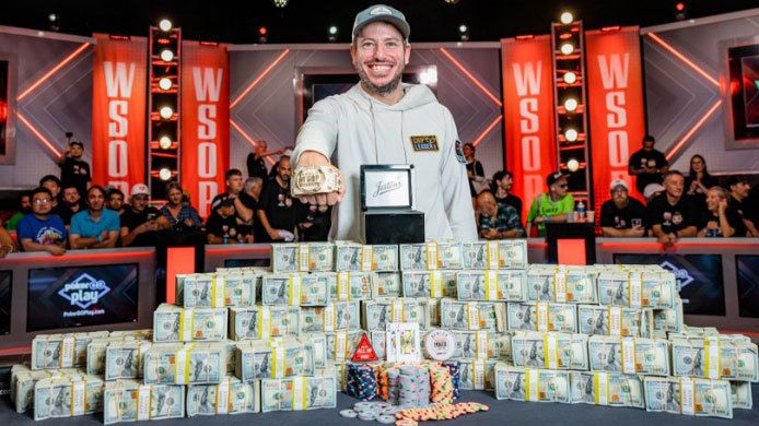 Daniel Weinman poses with a pile of money after winning the World Series of Poker top table.