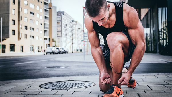 Fit man tying up shoes