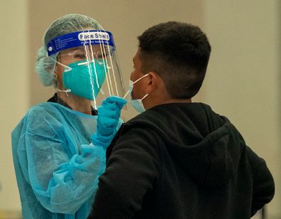 A medical professional gives a weekly rapid COVID-19 test to a fifth-grader on the first day of school at Los Angeles Unified School District at Montara Avenue Elementary School Monday.