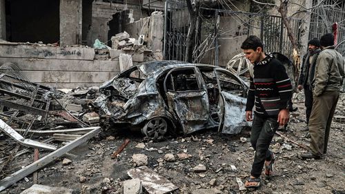 A boy walks past a destroyed car after several air strikes on Hamoria, rebels-held eastern al-Ghouta, (Photo: EPA).