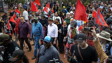 Luke Gosling, Yolngu Elder Djawa Yunupingu and Australian Prime Minister Anthony Albanese are escorted through the Garma Festival