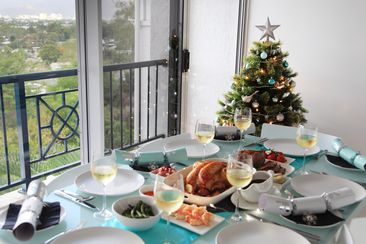 Christmas lunch on a hot summer day in modern apartment in tropical Cairns, Queensland, Australia.  Christmas tree and city view in background.