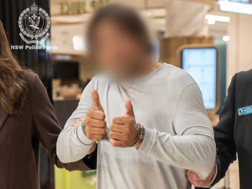 L'uomo ha mostrato il pollice in su a una telecamera all'aeroporto di Sydney.