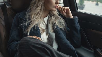 Stock image of a woman in a car going to work.