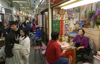 People line up at fortune-telling stalls outside Wong Tai Sin Temple.