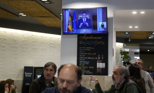 Customers have breakfast in a restaurant while Spanish Prime Minister Pedro Sanchez appears on a television broadcast in Madrid, Spain, Monday, April 29, 2024. 