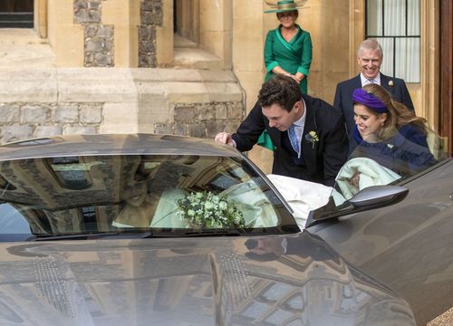 Princess Eugenie squeezes into the car, train and all, with a bit of help from new hubby and sis.