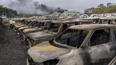 Burnt cars are lined up after unrest that erupted following protests over voting reforms in Noumea, New Caledonia