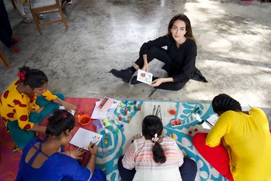 Jessica Kahawaty sit with girls who were rescued from child sex trafficking.