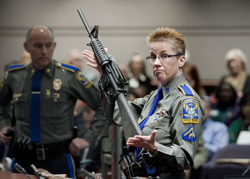 Firearms training unit Detective Barbara J. Mattson, of the Connecticut State Police, holds up a Bushmaster AR-15 rifle, produced by Remington Arms and the same make and model of gun used by Adam Lanza in the Sandy Hook School shooting