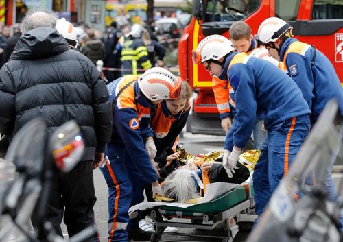 Emergency workers treat an injured woman after the explosion in Paris.