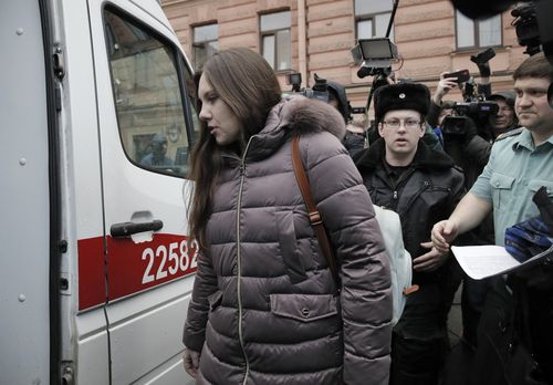 Alla Ilyina, who broke out of the hospital on Feb. 7 after learning that she would have to spend 14 days in isolation instead of the 24 hours doctors promised her, is escorted by a bailiffs form a court after a session in St.Petersburg, Russia, Monday, Feb. 17, 2020.A woman who escaped from a hospital in St. Petersburg, where she was being kept in isolation for possible inflection by the new coronavirus, was ordered by court on Monday to return back to the quarantine for at least two days.