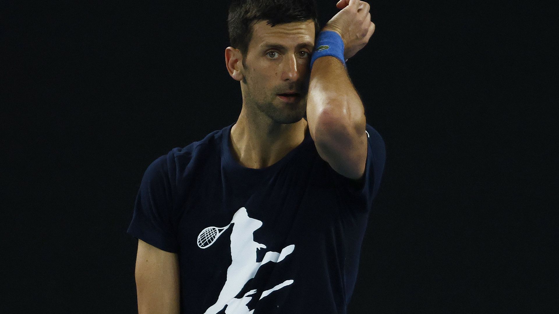 Novak Djokovic of Serbia wipes sweat during a practice session ahead of the 2022 Australian Open at Melbourne Park on January 14, 2022 in Melbourne, Australia.  