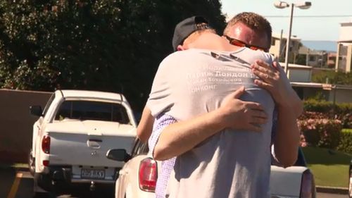 Joshua embraces his dad Andy after returning to the Redcliffe McDonald's where he was felled. (9NEWS)