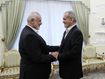 In this photo released by the Iranian Presidency Office, President Masoud Pezeshkian, right, shakes hands with Hamas chief Ismail Haniyeh