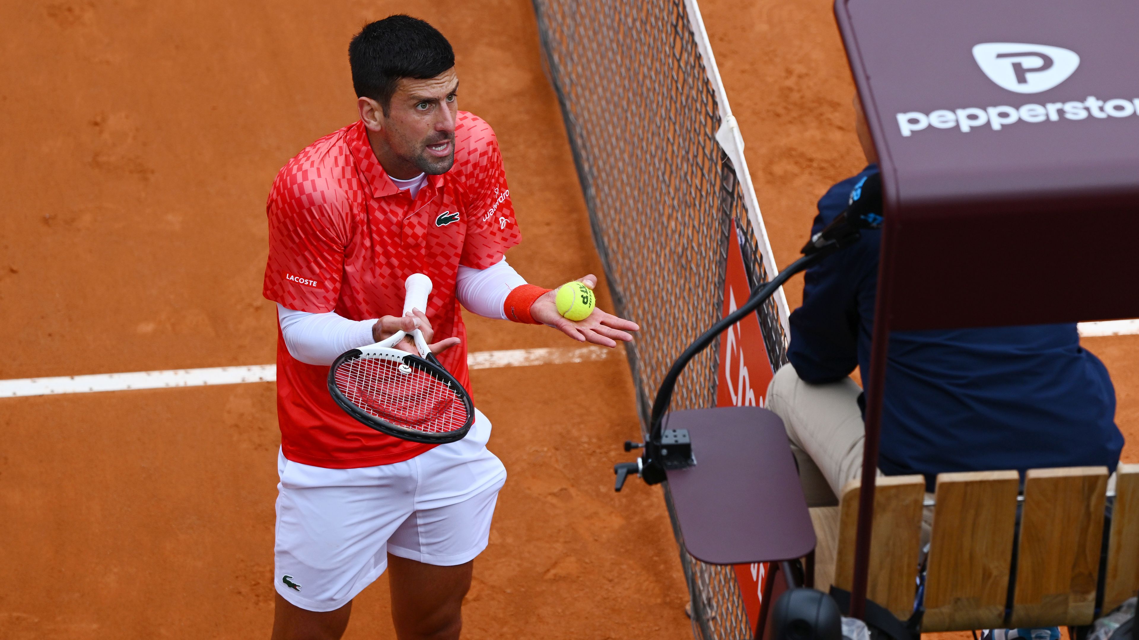 Novak Djokovic of Serbia speaks with the umpire against Holger Rune of Denmark.