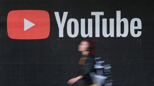A young woman wearing headphones walks past a billboard advertisement for YouTube on September 27, 2019 in Berlin, Germany. YouTube has evolved as the world's largest platform for sharing video clips. (Photo by Sean Gallup/Getty Images)