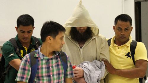 Philippine police operatives escort Australian Islamic preacher Robert Cerantonio, alias Musa, upon their arrival at the Ninoy Aquiono International Airport in Manila, Philippines, Friday, July 11, 2014. Chief Superintendent Prudencio Tom Banas said that Cerantonio and a Filipino woman were arrested in their rented apartment in Cebu province's Lapu-Lapu city.