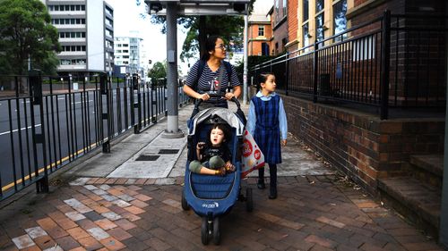 A Sydney mother drops her 8-year-old daughter off at Chatswood Public School, in Sydney.