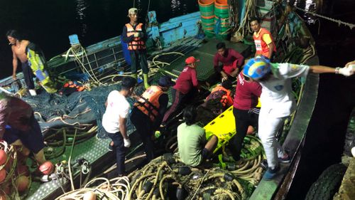 Tourists from a boat that sank are helped onto a pier from a fishing boat. Picture: AAP