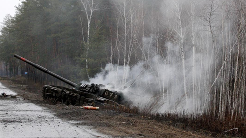 Smoke rises from a destroyed Russian tank on the side of a road in the Lugansk region of Ukraine. 