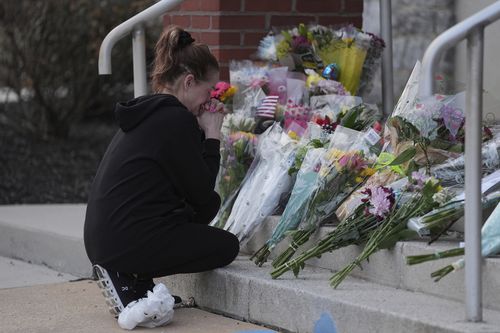 Linda Shields leaves flowers in front of the West York Police Department after a police officer was killed responding to a shooting at UPMC Memorial Hospital in York, Pa. on Saturday, Feb. 22, 2025. (AP Photo/Matt Rourke)