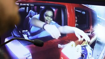 Surveillance video of Philana Holmes reaching for two Happy Meals in the drive-thru at McDonald&#x27;s is shown on a courtroom monitor.