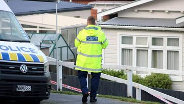A police officer outside the cordoned-off home in Dunedin.